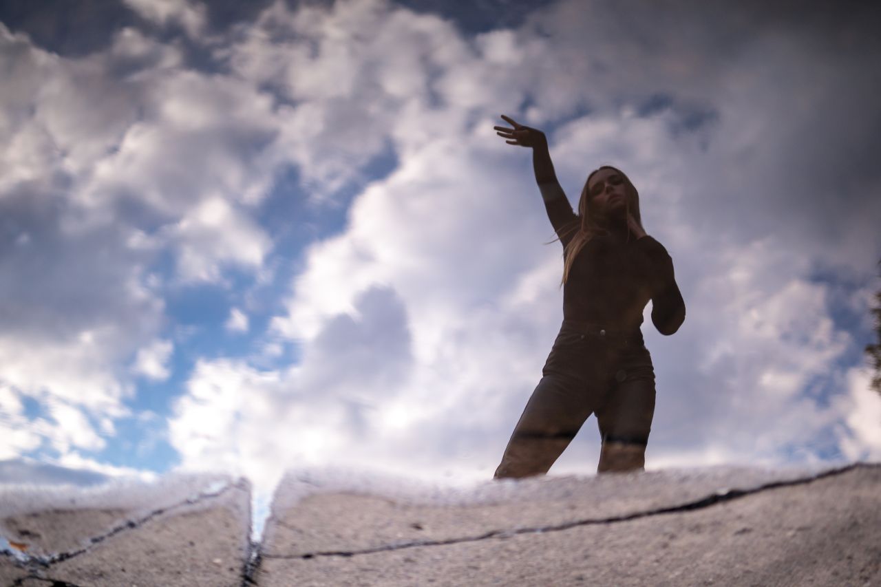 Femeie care arată spre cer și se gândește la masturbare