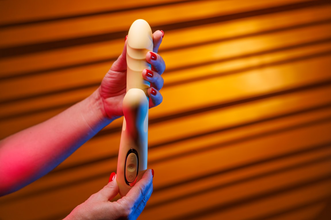 Zmysłowy dotyk - kobieta z czerwonym manicure używa wibratora